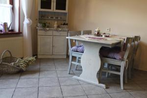 a white table in a kitchen with chairs and a table at Zajazd Podlesie in Chociwel