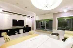 a dining room with a table and a tv at Renaissance Hotel Pohang in Pohang +26 photos