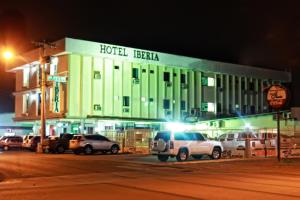 un hotel con coches aparcados delante de él por la noche en Hotel Iberia, en David