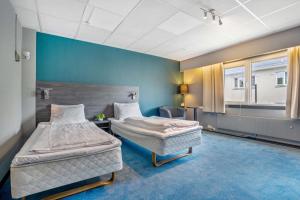 2 camas en una habitación con paredes azules en Sure Hotel by Best Western Haugesund, en Haugesund
