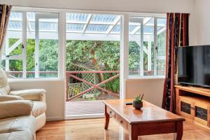 ein Wohnzimmer mit einem großen Fenster und einem TV in der Unterkunft 3 Bedroom In Onehunga w Parking - Wifi - Netflix in Auckland