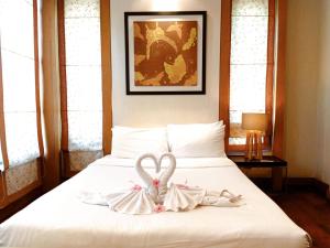 a white bed with two swans on it at Royal Sammuk Villa in Bangsaen