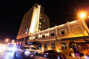 um edifício com carros estacionados em frente a ele à noite em Hotel Fray Marcos em Nogales