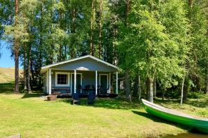 a small house with a boat in the yard at saunamökki Rauhala,LaatuLomat in Juva