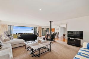 a living room with a couch and a tv at Waitahanui Lakefront Escape - Waitahanui Home in Waitahanui