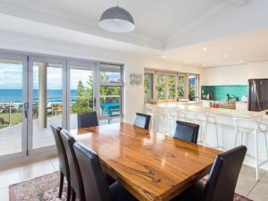 une cuisine et une salle à manger avec une table et des chaises en bois dans l'établissement 56 Becker Road, à Forster