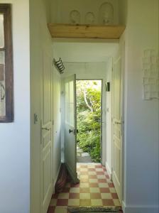 a hallway with two doors and a checkered floor at La petite maison du jardin d'Apollon in Dourdan