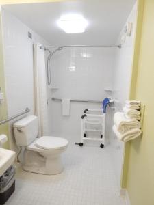 La salle de bains blanche est pourvue de toilettes et d'un lavabo. dans l'établissement Super 8 by Wyndham White River Junction, à White River Junction