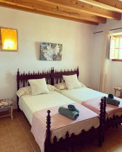 1 dormitorio con 2 camas y toallas. en Finca Albenyeta, en Llucmajor
