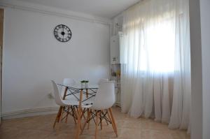 a dining room with a table and chairs and a clock at Apartament bell confort in Tulcea