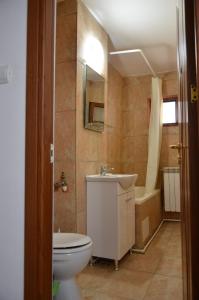 La salle de bains est pourvue de toilettes, d'un lavabo et d'une baignoire. dans l'établissement Apartament bell confort, à Tulcea