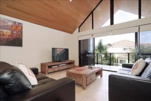 a living room with two couches and a tv at Swan River Apartment in Perth