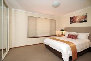 a bedroom with a large bed and a window at Swan River Apartment in Perth