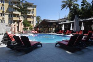 a swimming pool with lounge chairs and umbrellas at Kleopatra Fatih Hotel in Alanya