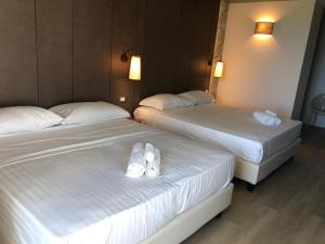 two beds in a hotel room with white shoes on them at Hotel Life in Rimini
