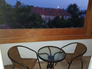 2 stoelen en een tafel op een balkon met een raam bij STUDIO APARTMENTS in Alba Iulia