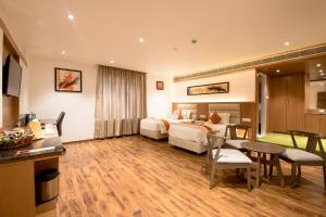 a hotel room with a bed and a table at Kyriad Hotel Gulbarga by OTHPL in Gulbarga