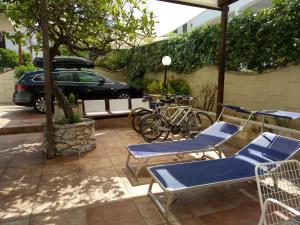 um pátio com cadeiras azuis e um carro estacionado em Casa Vacanze Mare Gargano em Rodi Garganico