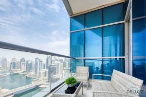 een balkon met stoelen en uitzicht op de stad bij Cozy 1BR at Bay Central 1 Dubai Marina by Deluxe Holiday Homes in Dubai