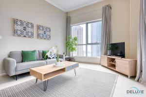 een woonkamer met een bank en een tv bij Cozy 1BR at Bay Central 1 Dubai Marina by Deluxe Holiday Homes in Dubai