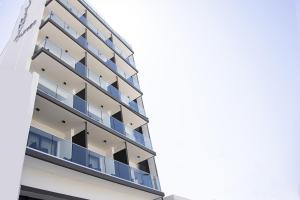 an apartment building with blue balconies against a sky at Jimmy's Suites in Larnaca