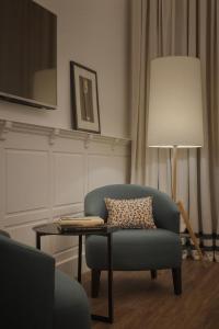 a living room with a chair and a table and a lamp at TOC Hostel Malaga in Málaga