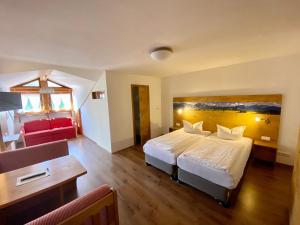 Gasthof-Hotel Höhensteiger في روزنهايم: غرفة بالفندق سرير وكرسي احمر