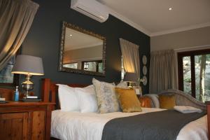 a bedroom with a bed with a mirror on the wall at Klipkoppie Cottage in Nelspruit
