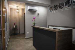 a lobby with a reception counter with flowers on the wall at Jimmy's Suites in Larnaca