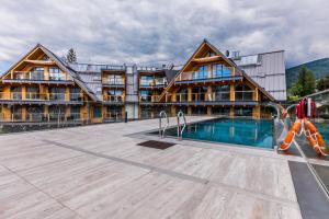 a large building with a swimming pool in front of it at Luxury Apartments in Zakopane