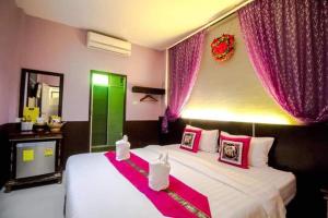 a bedroom with two beds with pink and green curtains at ฝ้ายคำ บูธีค เชียงใหม่ in Chiang Mai