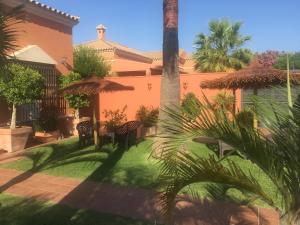 a courtyard with a palm tree and a building at Chalet Martin in Chiclana de la Frontera