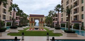 an arch in the middle of a courtyard with palm trees at Marrakesh Huahin Condo in Hua Hin