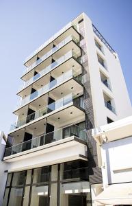 a tall white apartment building with windows at Jimmy's Suites in Larnaca
