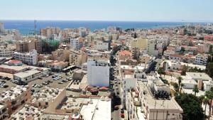 an aerial view of a city with buildings and the ocean at Jimmy's Suites in Larnaca