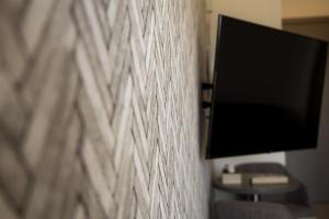 ein Fernseher hängt an einer Wand neben einer Couch in der Unterkunft Jimmy's Suites in Larnaka