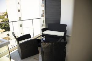 a table and chairs on a balcony with a window at Jimmy's Suites in Larnaca