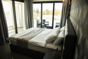 a bedroom with a bed and a large window at Jimmy's Suites in Larnaca