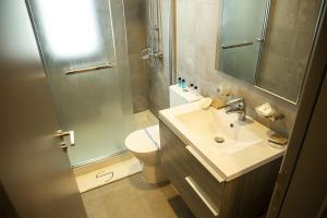 a bathroom with a toilet and a sink and a shower at Jimmy's Suites in Larnaca