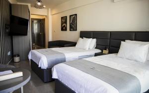 a hotel room with two beds and a flat screen tv at Jimmy's Suites in Larnaca
