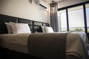 a bedroom with a large bed with a large window at Jimmy's Suites in Larnaca