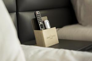 a remote control sitting in a box on a bed at Jimmy's Suites in Larnaca