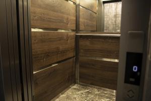 a bathroom with a wooden door with a mirror at Jimmy's Suites in Larnaca