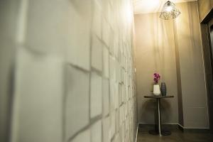 a hallway with a white tiled wall and a table at Jimmy's Suites in Larnaca