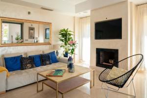 ソトグランデにあるPolo Royale Waterfront Luxury Apt - 3 terraces and poolのソファと暖炉のあるリビングルーム