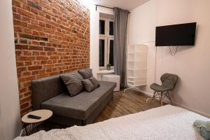 ein Wohnzimmer mit Sofa und Ziegelwand in der Unterkunft Dream Aparts-Rewolucji 2 in Łódź