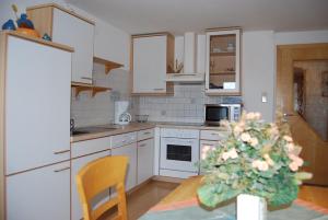 a kitchen with white cabinets and a table with a christmas tree at Bauernhof Grafenhof in Ebbs