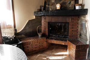 sala de estar con chimenea de ladrillo y TV en Lanjarón Rural Apartamentos, en Lanjarón