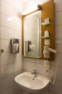 a bathroom with a sink and a mirror at Hotel Pegasus in Munich