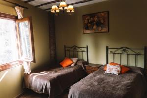 1 dormitorio con 2 camas individuales y ventana en Lanjarón Rural Apartamentos, en Lanjarón